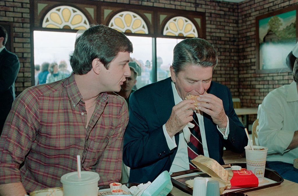 10/15/1984-Tuscaloosa, AL-President Ronald Reagan takes a bite of a Big Mac, as Charles Patterson chats with him during a brief campaign stop.