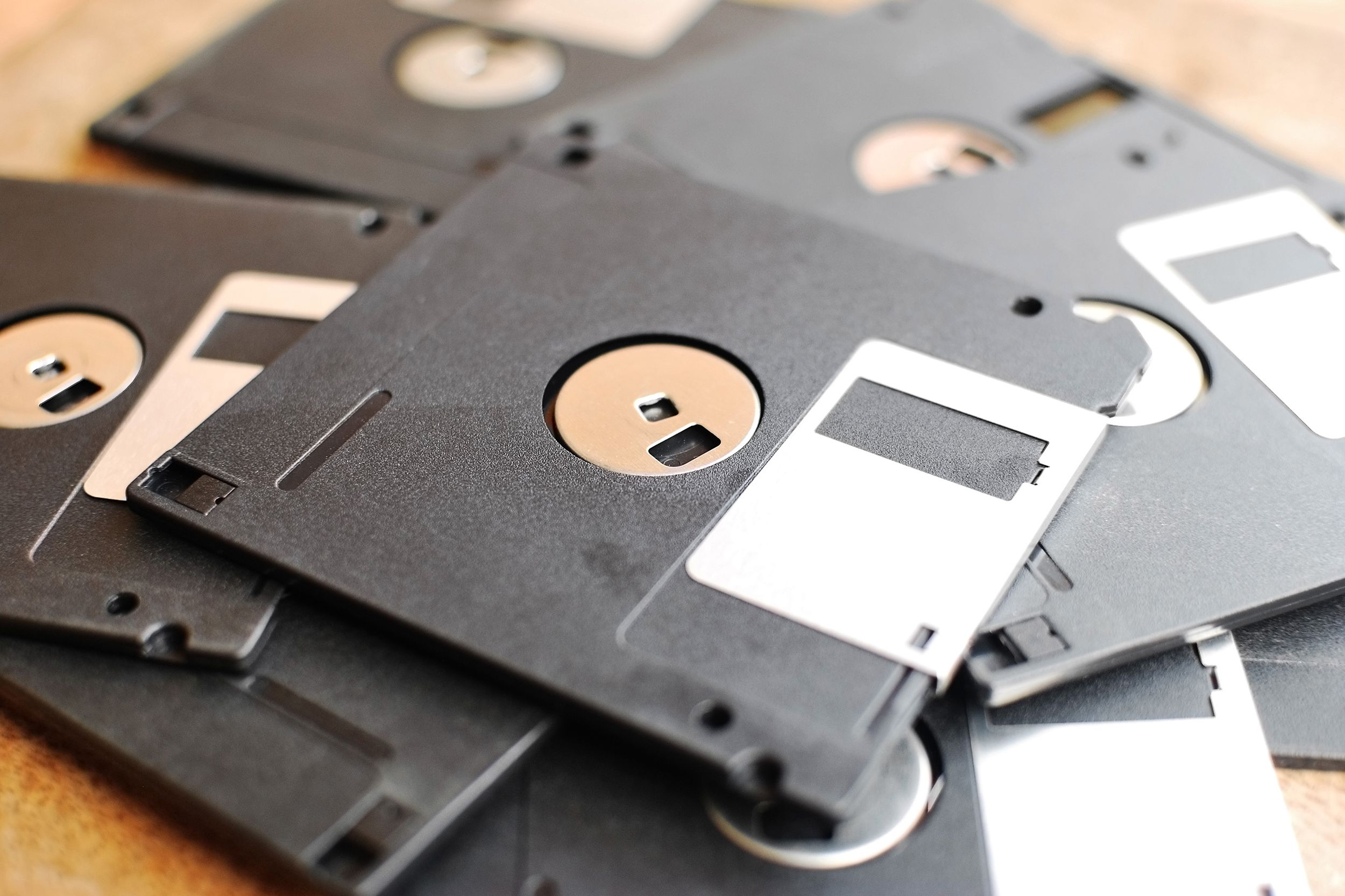 Pile of several floppy disks on a wooden desk