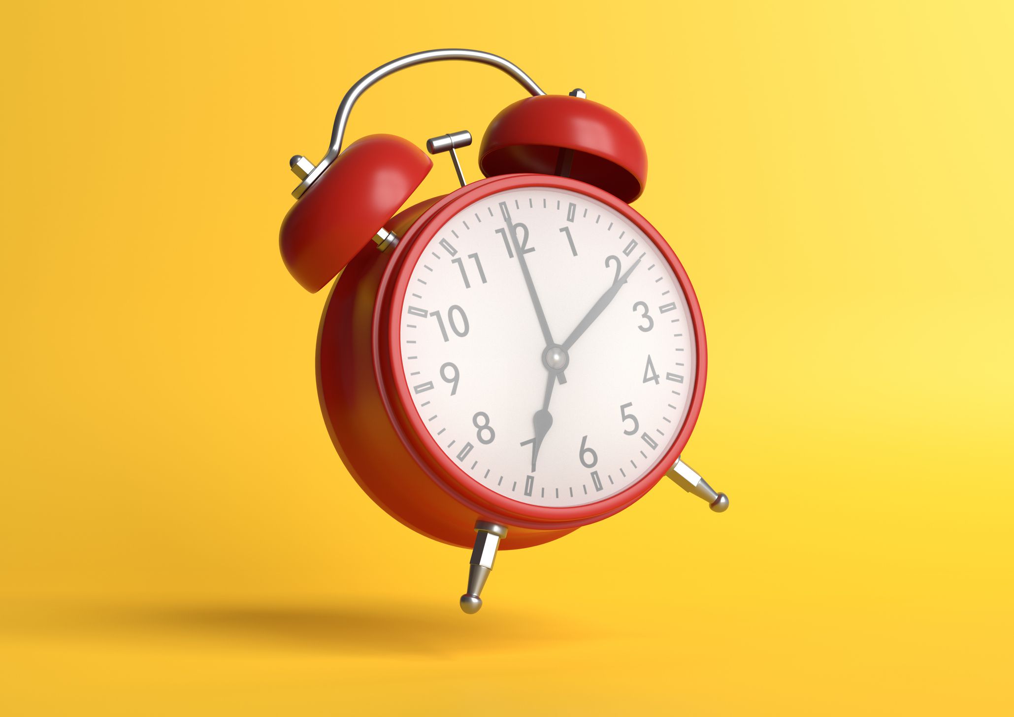 Red vintage alarm clock jumping in the air with a bright yellow background