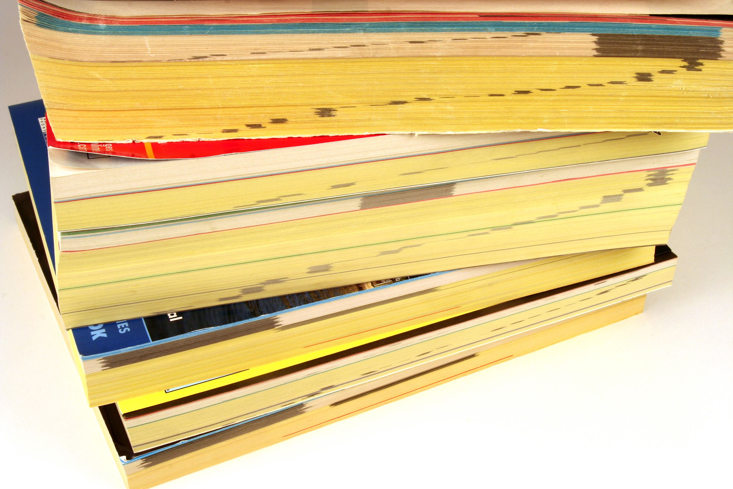 Stack of six phone books on a white background