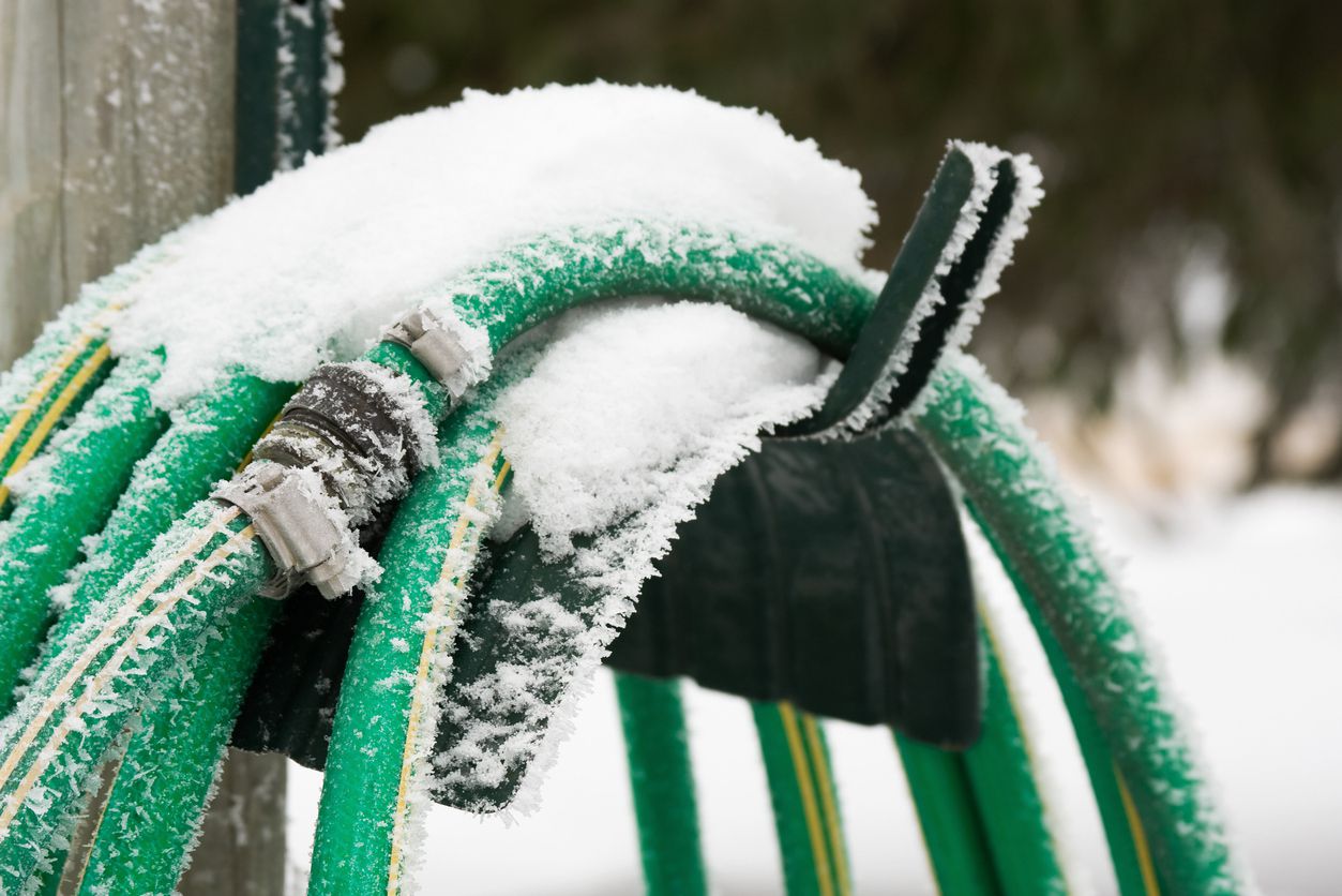 Garden hose covered with snow and frost