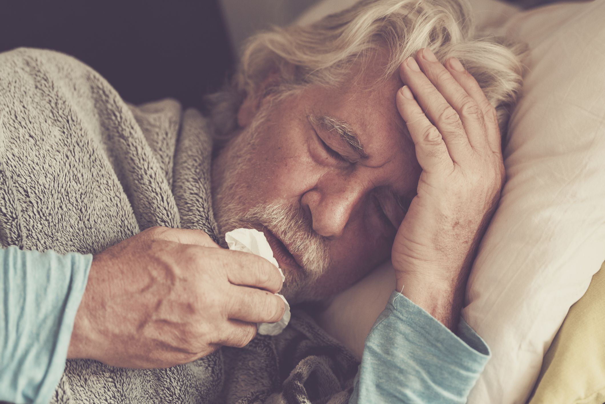 Old people senior man with winter seasonal illness fever cold problems drinking a pharmacy medicine or hot tea to go healthy - concept of mature retired with disease