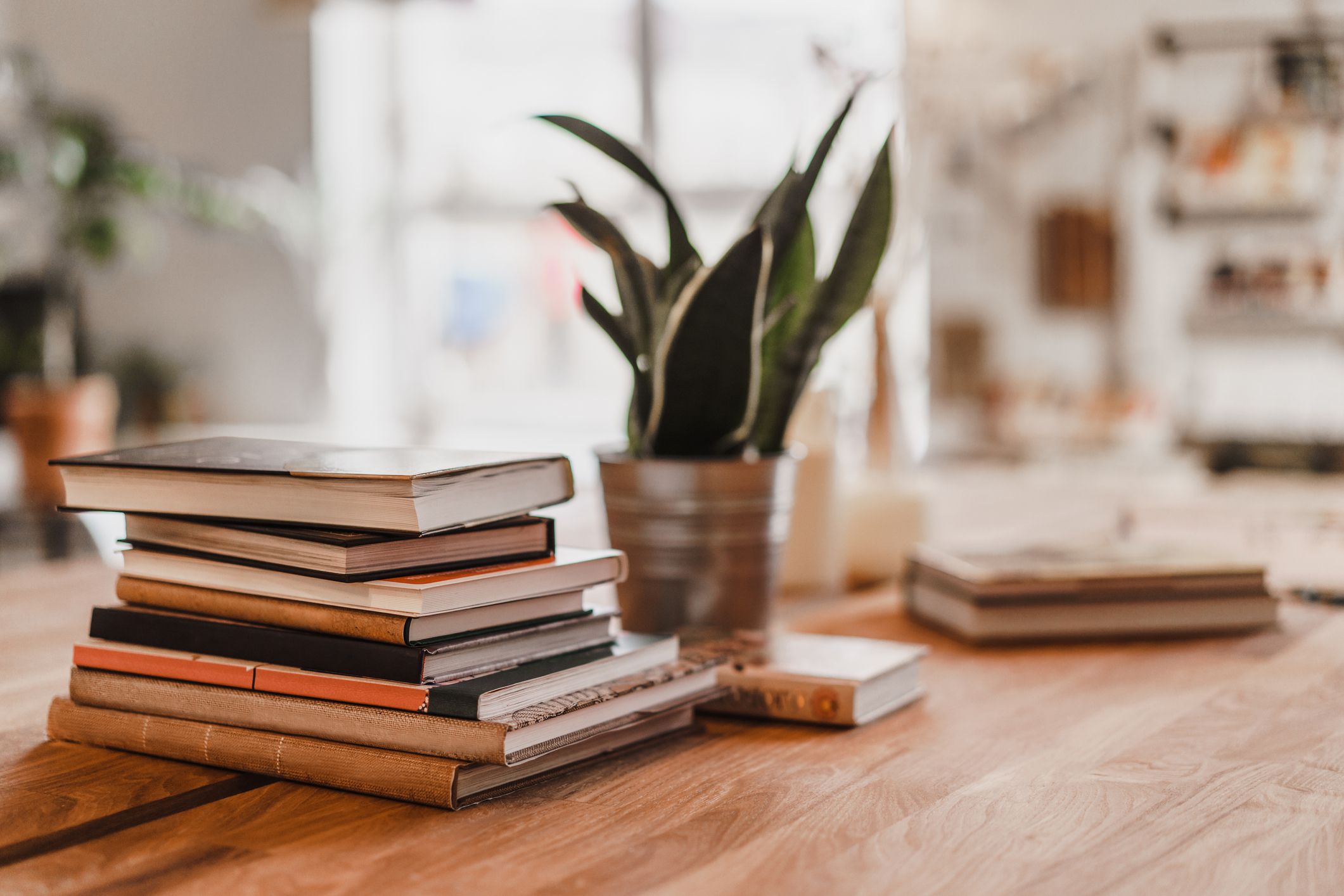 Stack of colorful books on wooden table in the room. Selective focus.