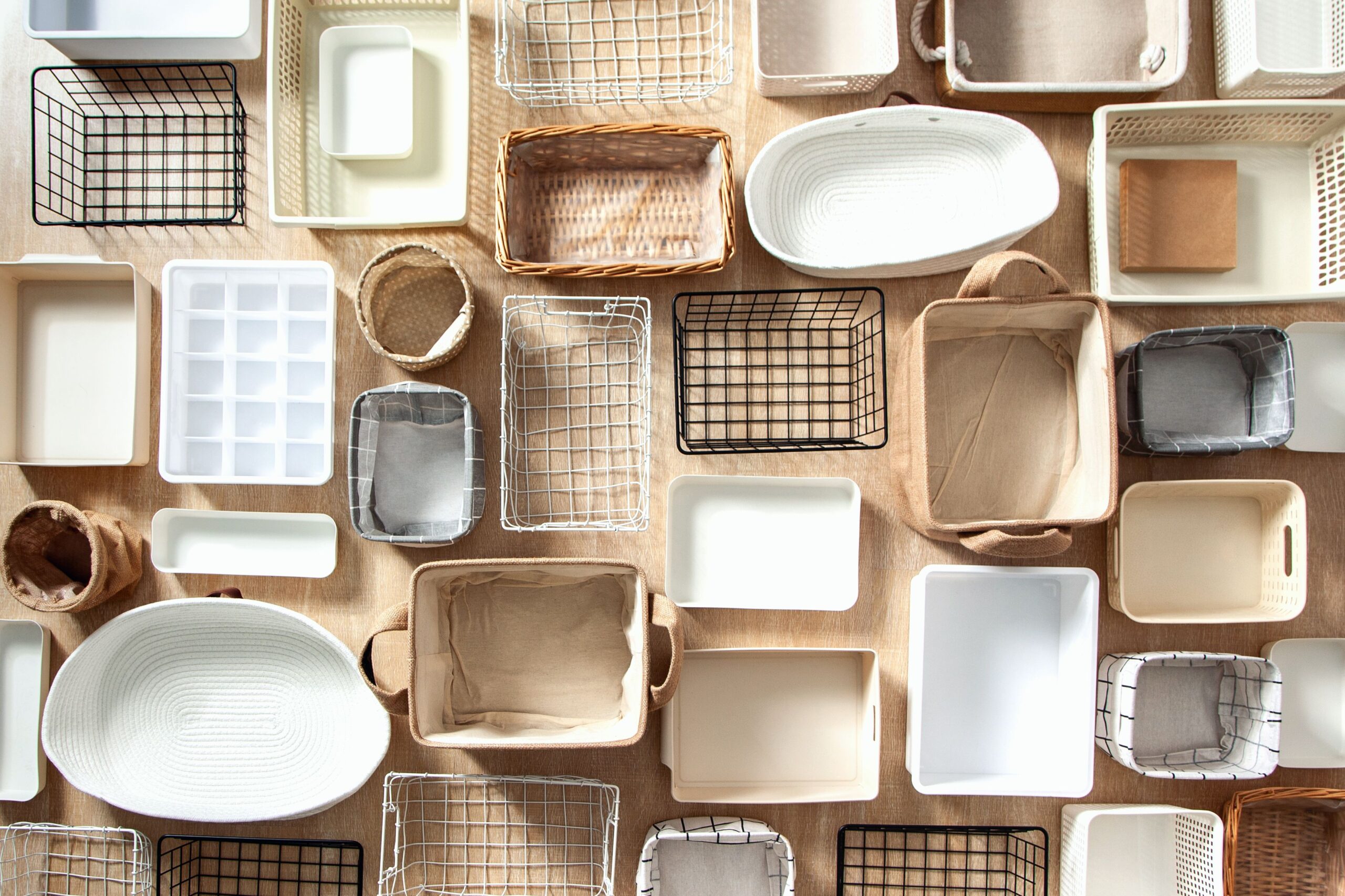 Flat lay of Marie Kondo's storage boxes, containers and baskets with different sizes and shapes for tidying up wardrobe. KonMari method organizer boxes set. Closet organizing concept.