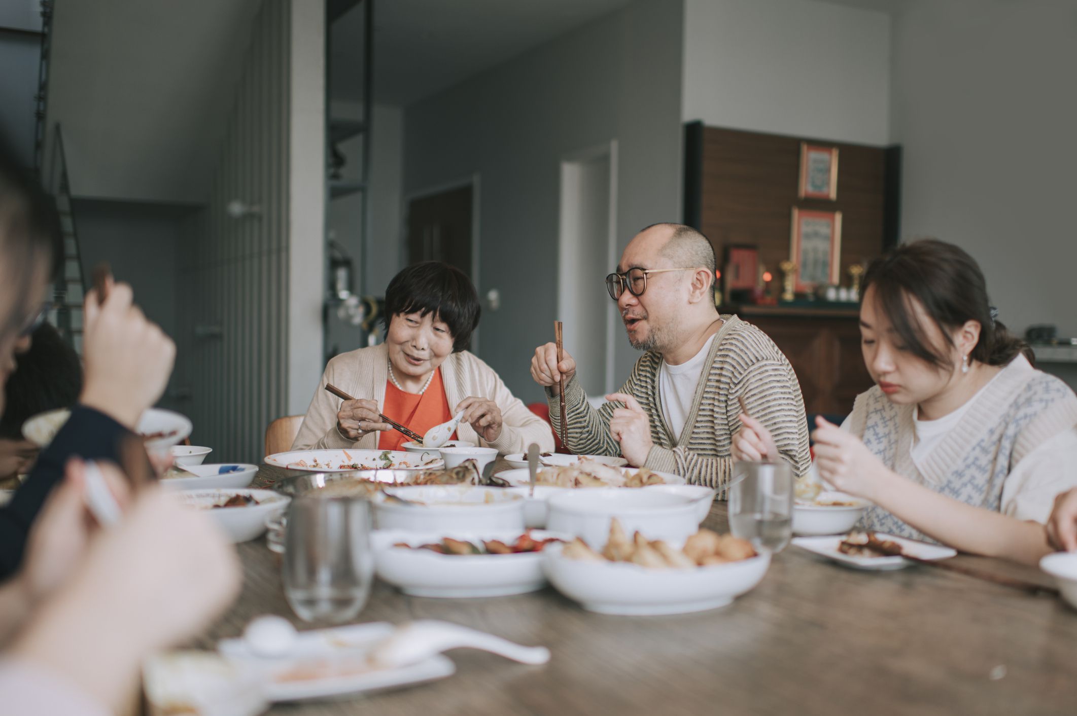 Asian chinese family chinese new year reunion dinner having traditional dishes at dining table