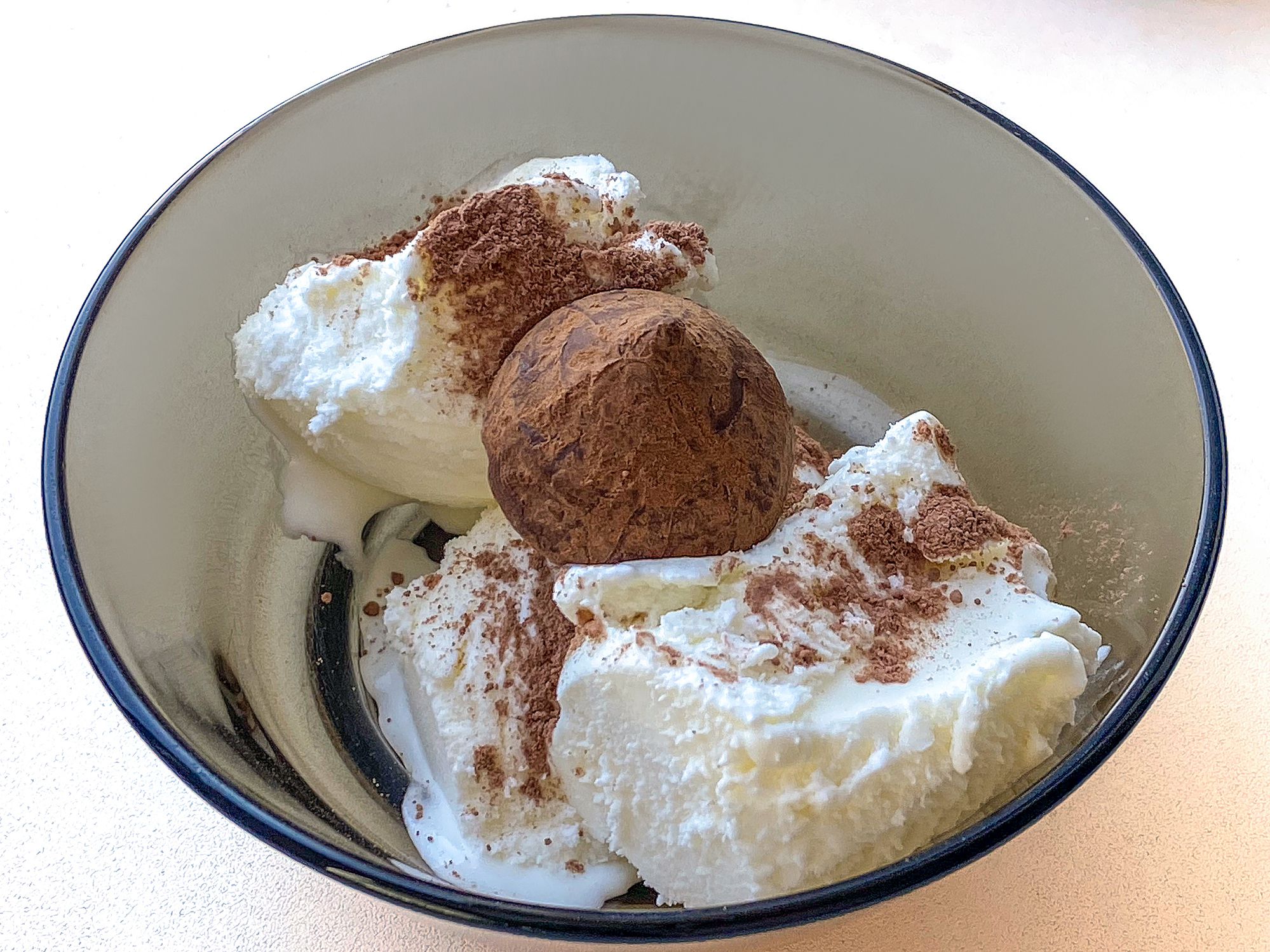 Ice cream with chocolate and cocoa powder on a plate. Cold dessert.