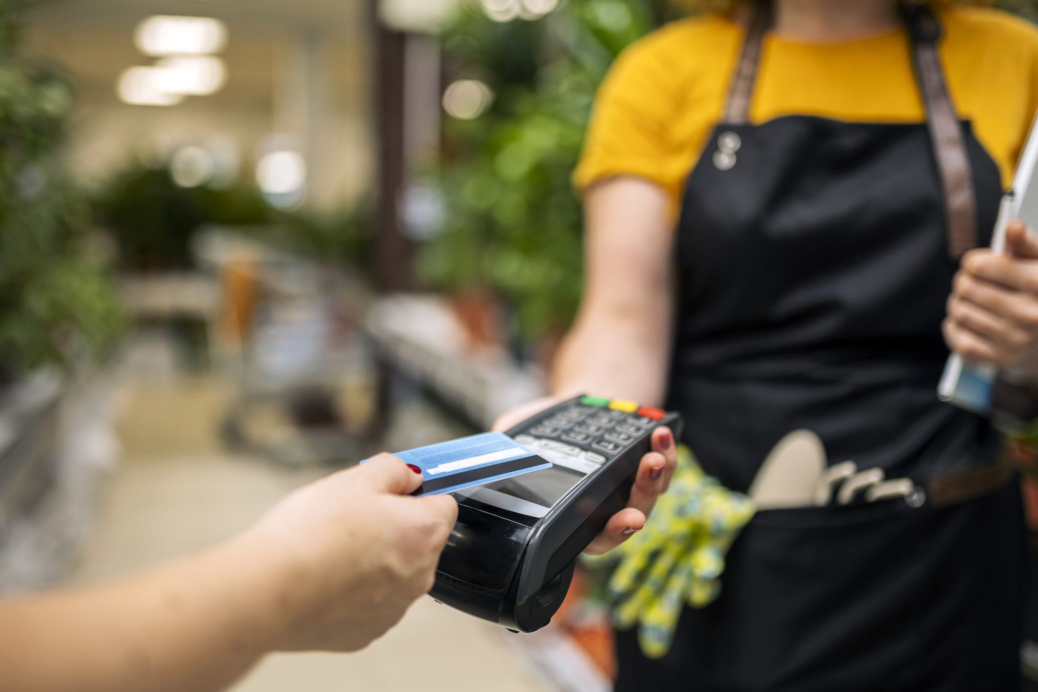 Greenhouse workers selling pottered flowers ,credit card purchase