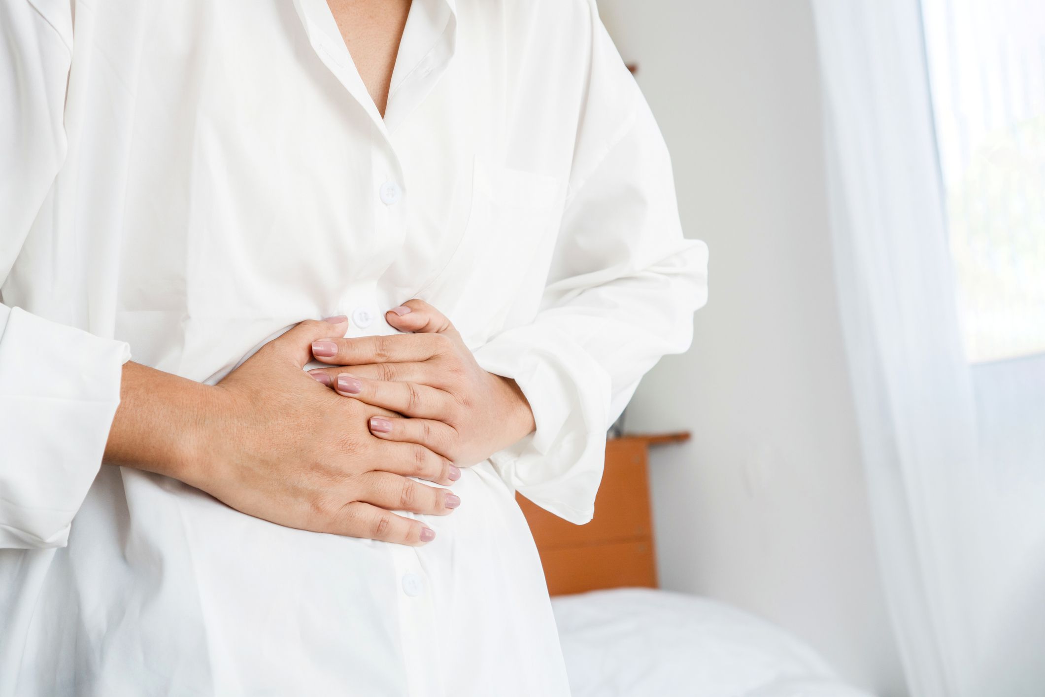 closeup woman having digestive system hand holding stomach pain