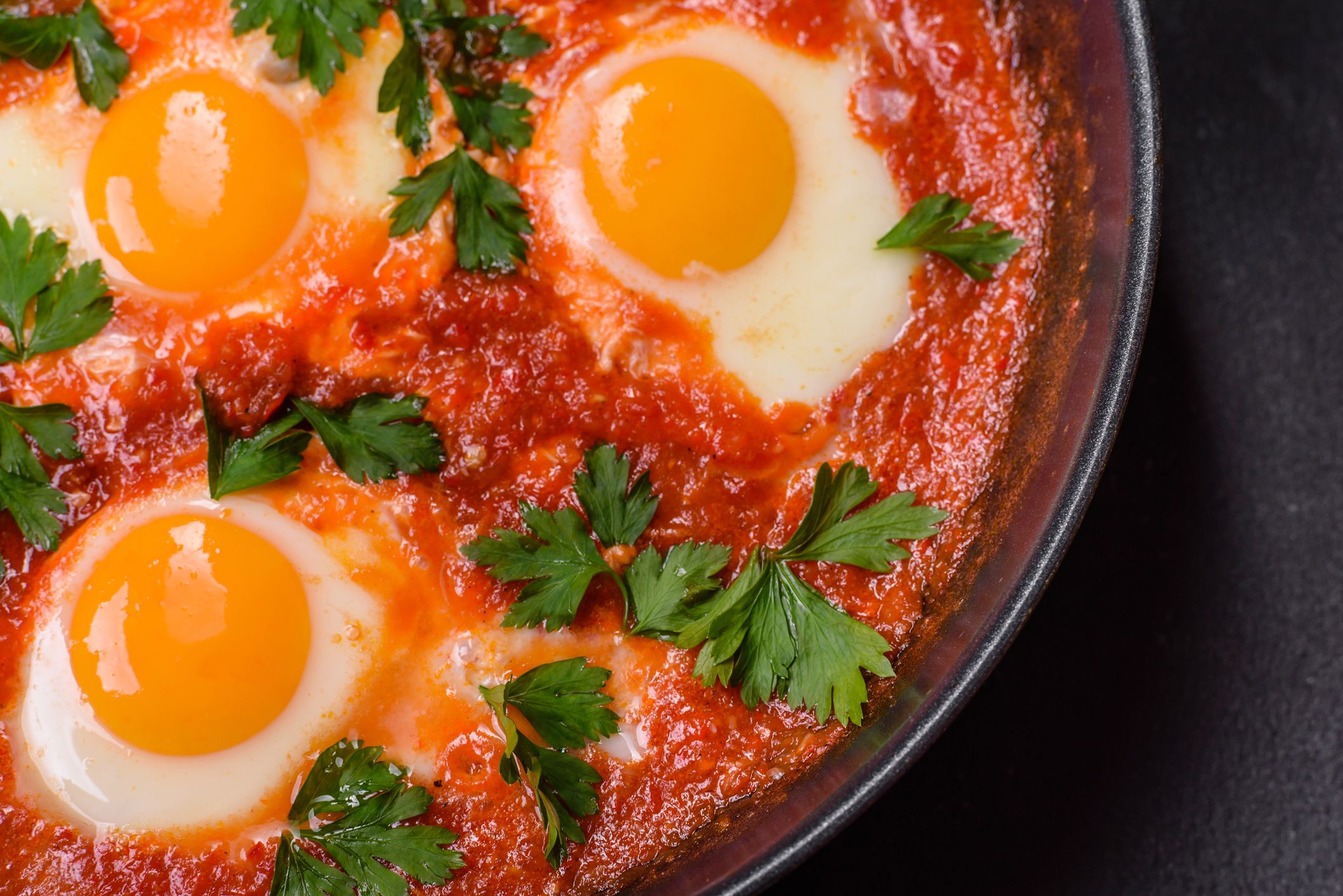 Shakshuka, a dish with fried eggs with tomato sauce, sweet pepper, garlic, onions, spices and herbs. Hearty and delicious breakfast