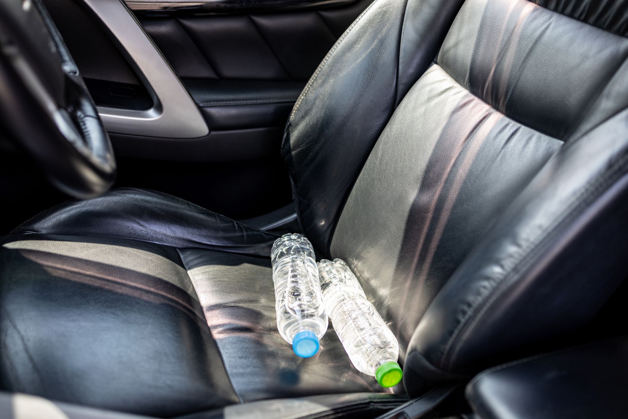 Plastic bottle of water placed on car seat and exposed to sun in sunny day,bottle of drinking water in car,sunlight,very hot,heating temperature,cause danger if parked in the sunshine for a long time