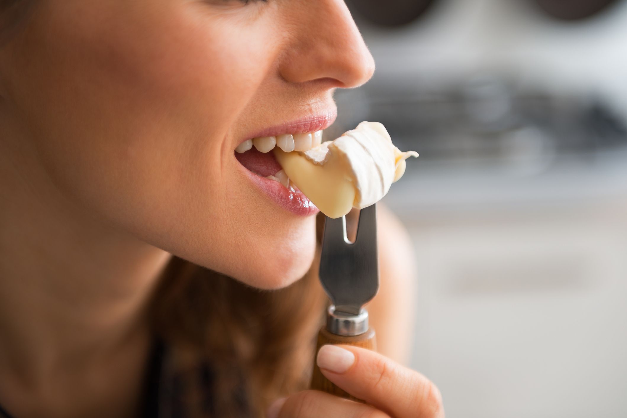 Closeup on young woman eating camembert