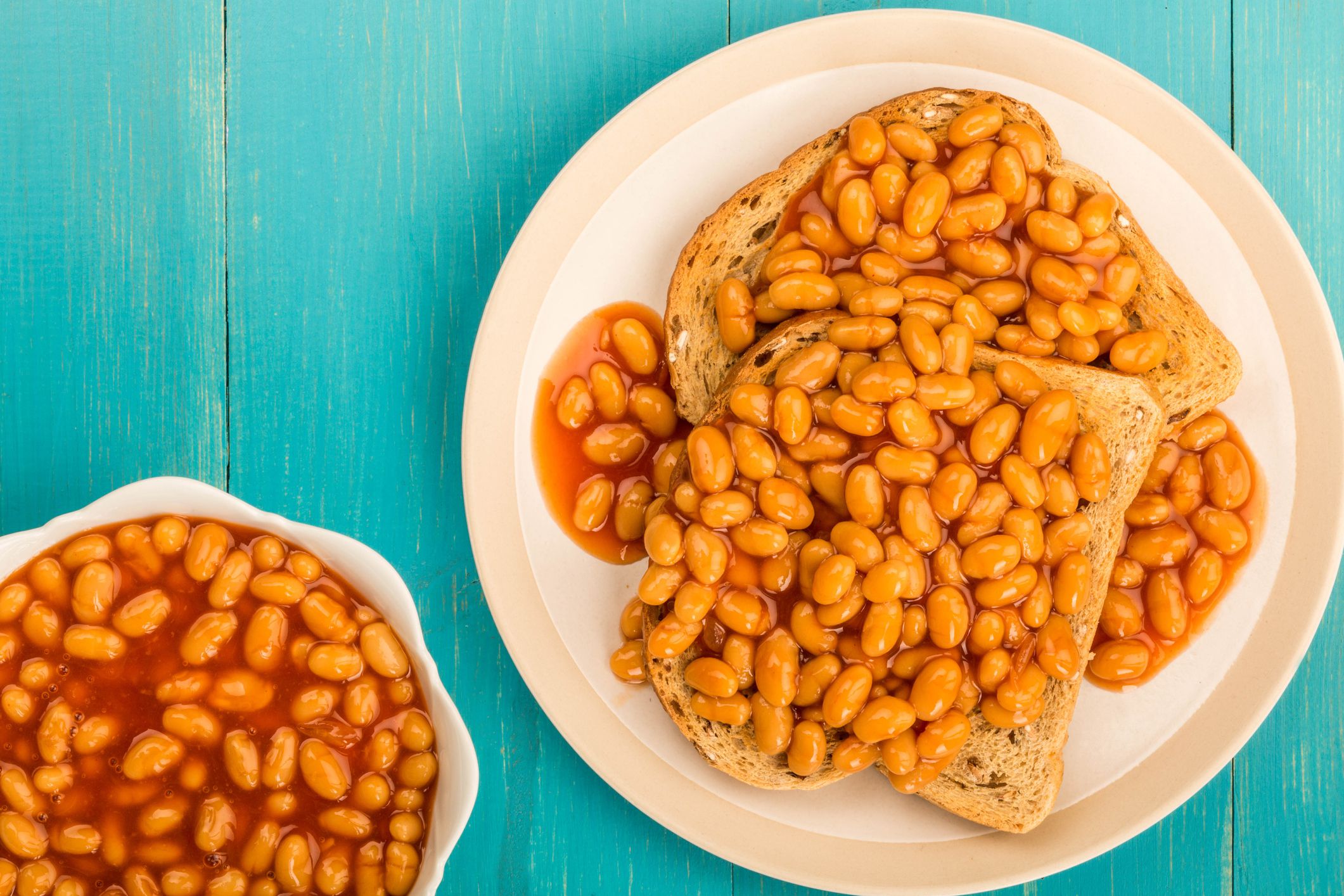 Baked Beans in Tomato Sauce on Toast On A Blue Wooden Background With Copy Space