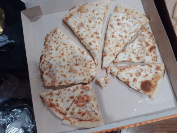 A pizza cut into several slices in a cardboard box.