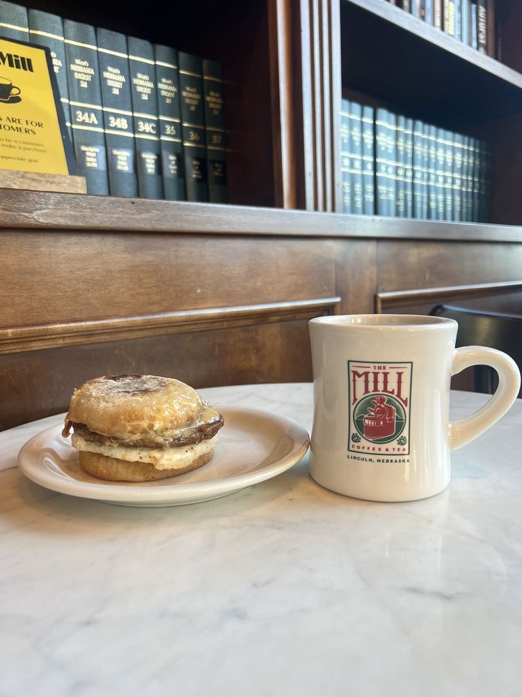 a breakfast sandwich and.a mug of coffee