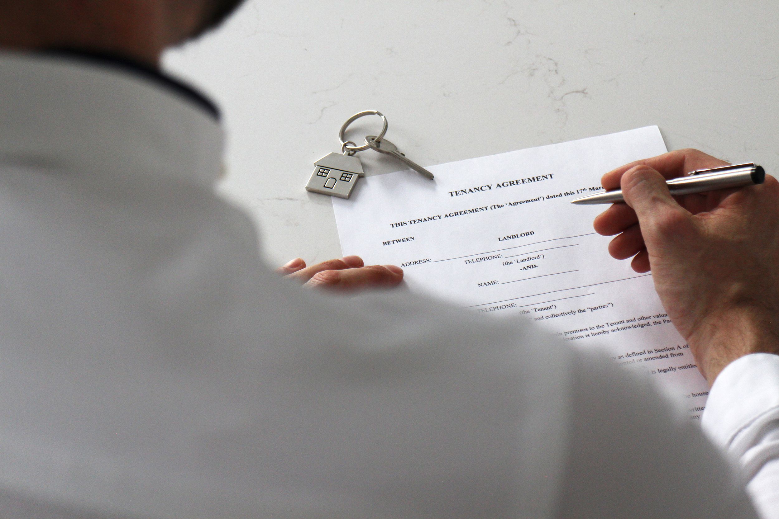 man signing tenancy agreement