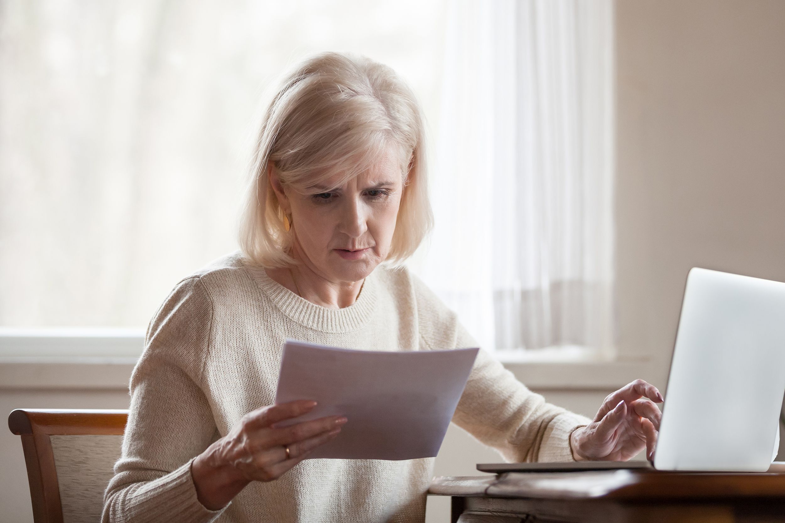 serious frustrated middle aged woman troubled with domestic bills