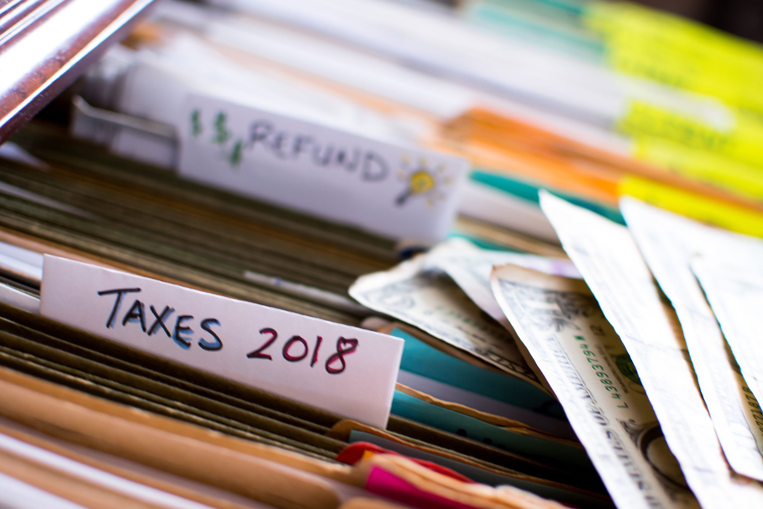 tax refund conceptual tax season tax preparation photography with files and tax forms in filing cabinet and words refund and taxes 2018 written on file folders