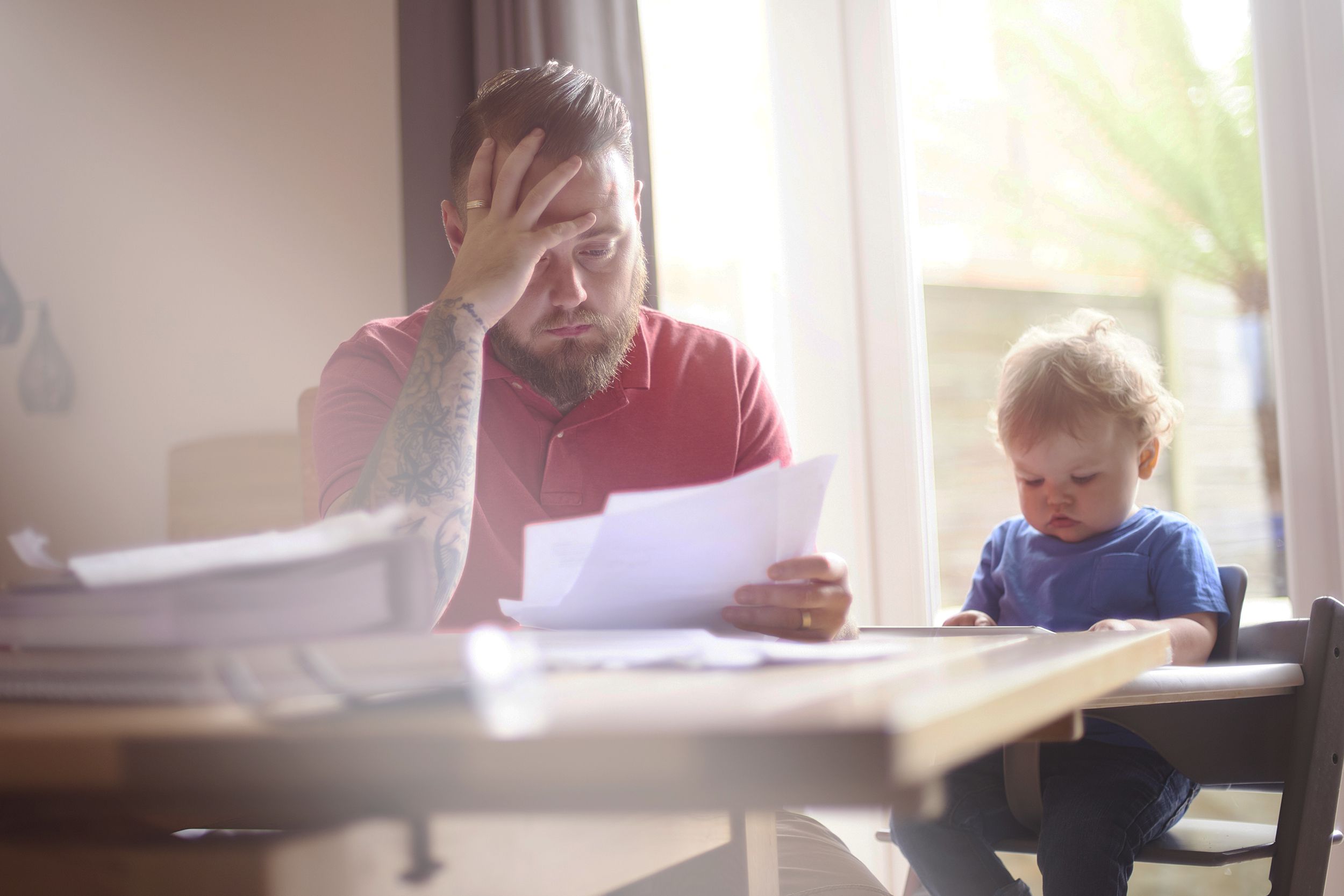father sits with his toddler at the dining table