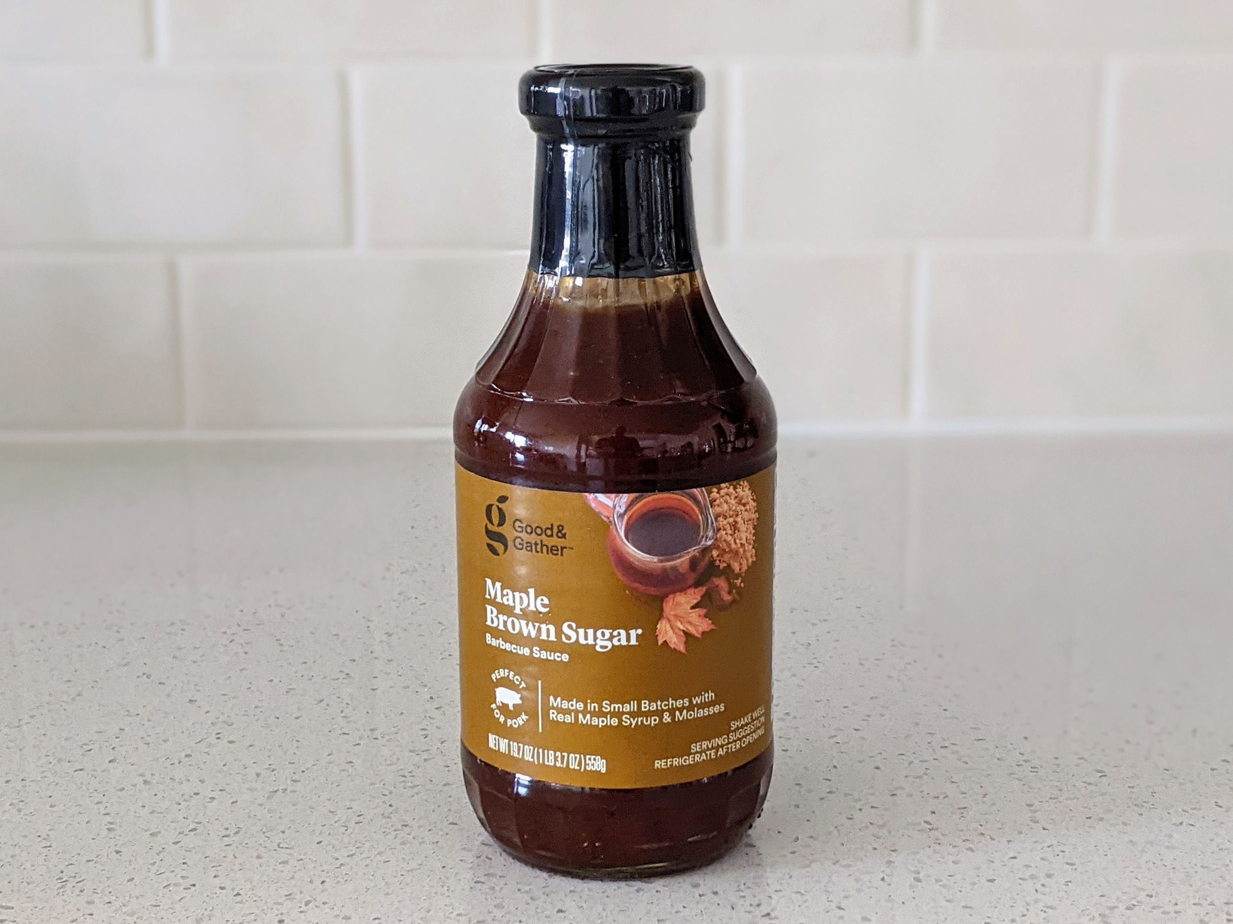 A Bottle of Good & Gather Maple Brown Sugar on a beige countertop, beige kitchen wall tile in the background