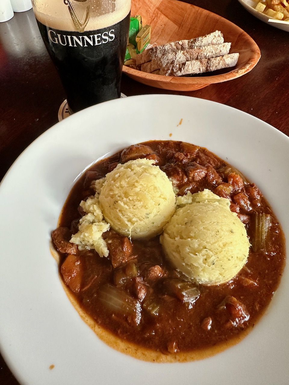 Irish Stew with Mashed Potatoes on top with a pint of Guinness and brown bread