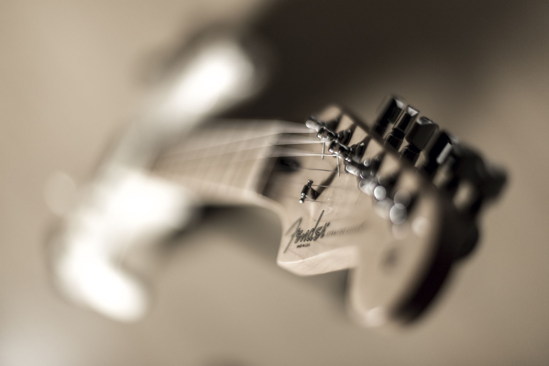 Closeup of Fender Stratocaster logo on an Olympic White Fender American Standard Stratocaster electric guitar