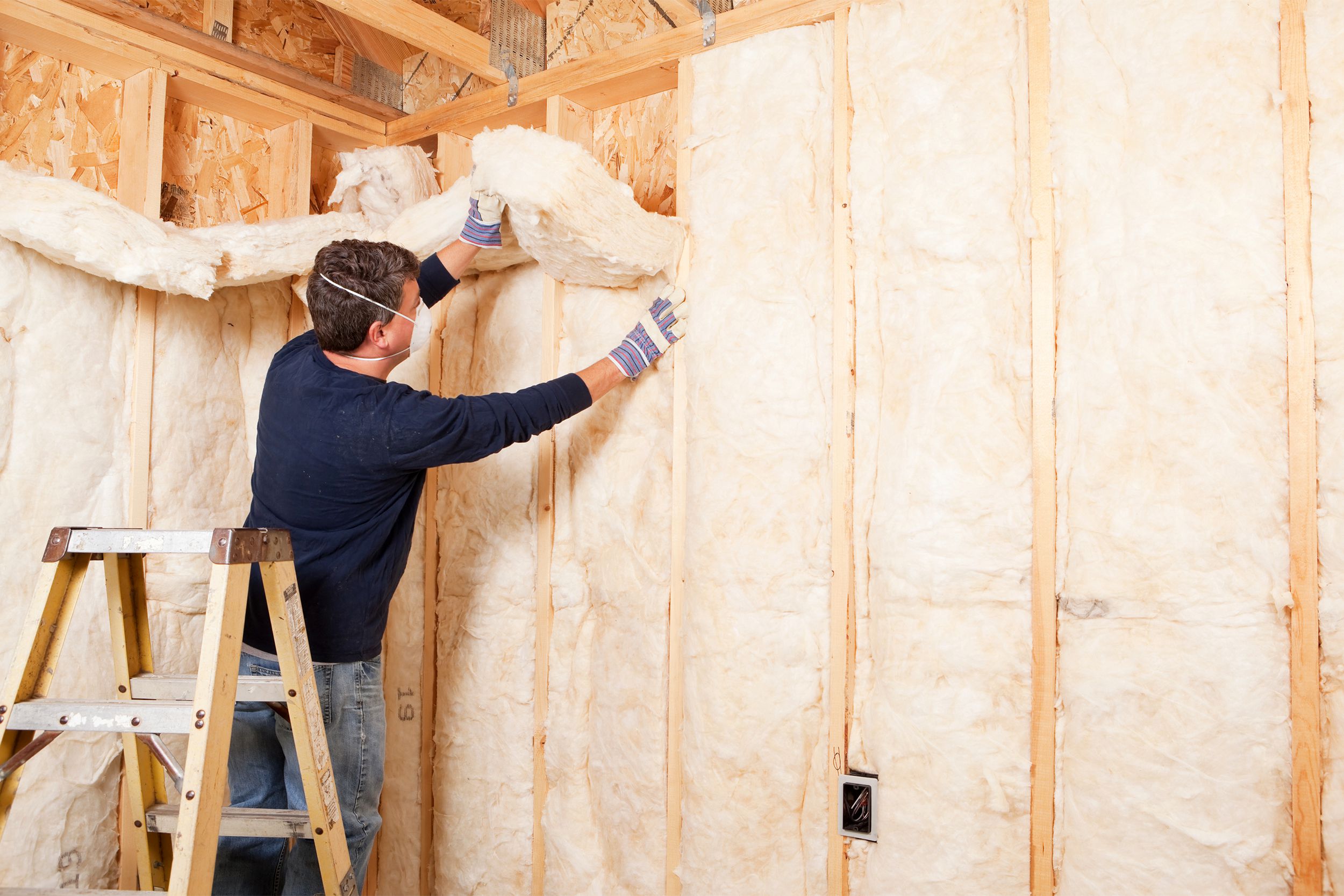 Man installing insulation in a house