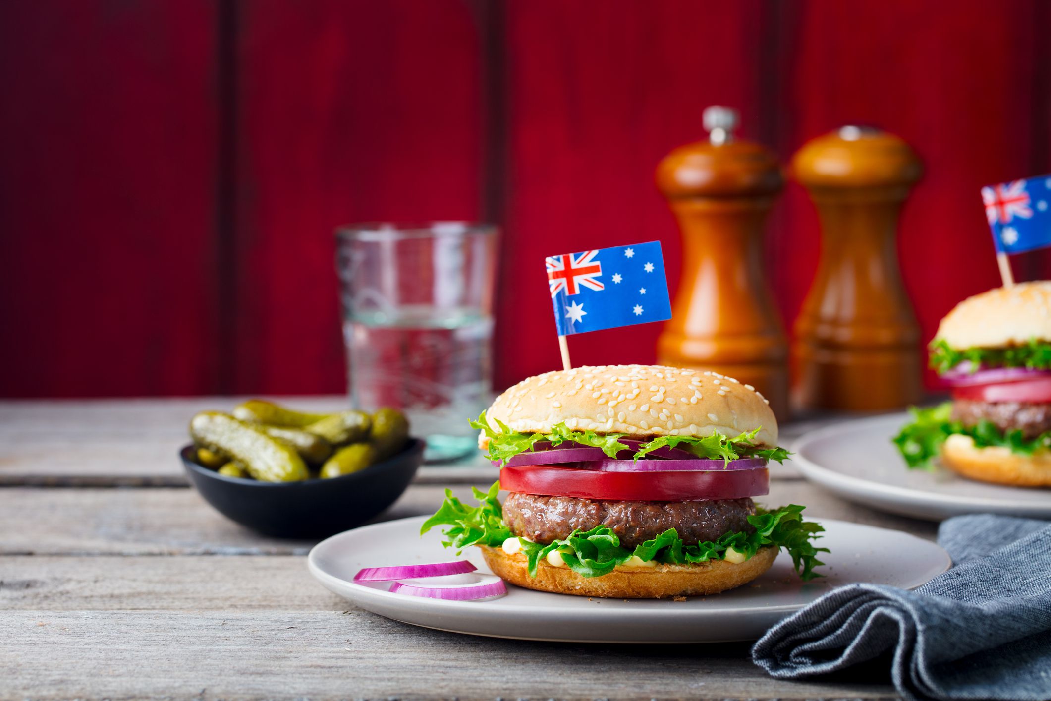 Burger with Australian flag on top. Wooden background. Copy space