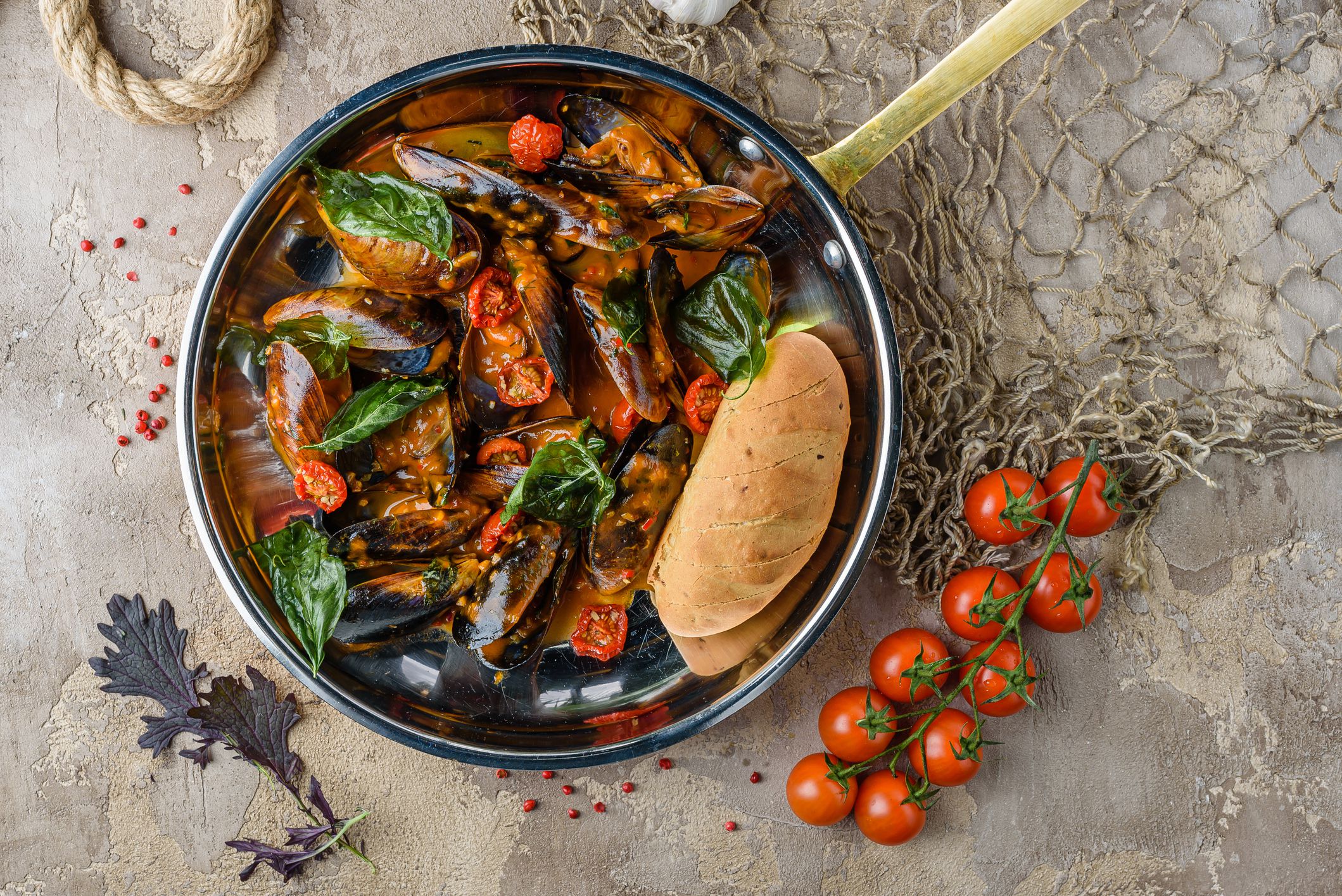 Mussels in a pan with tomato sauce andbasil leaves.View from above