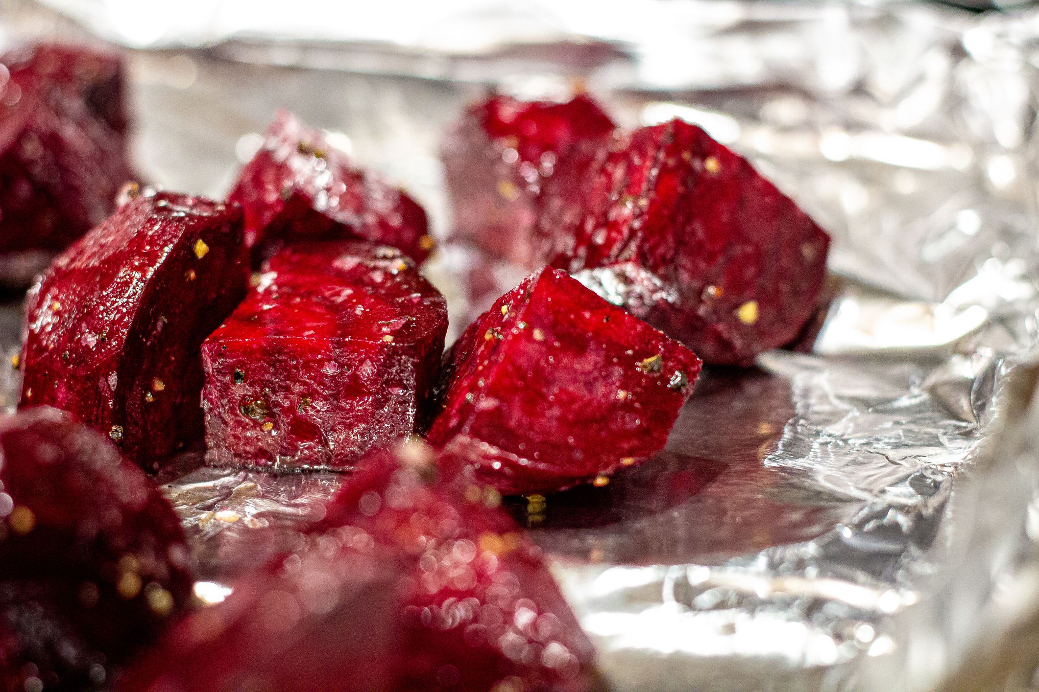 Close-Up Shot of Fresh Chopped Salt & Pepper & Olive Oil Seasoned Red Beets On an Aluminum Foil Lined Baking Pan Tray Ready to Cook for Dinner