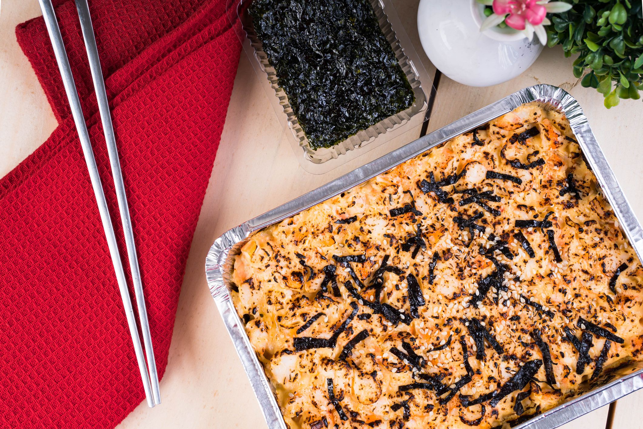 a tray of baked sushi, layered rice, egg, Japanese mayo and topped with meat or seafood;