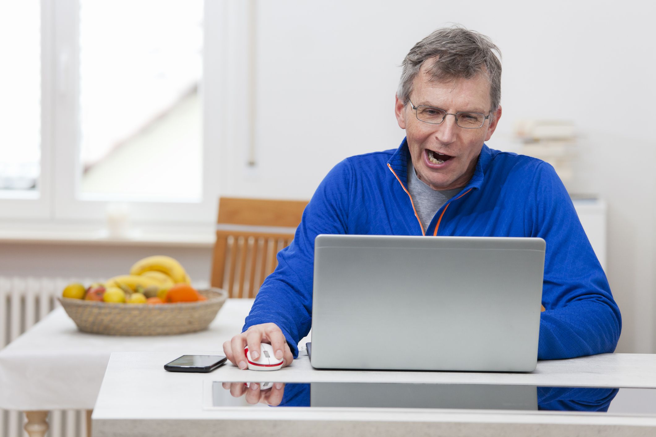 Mature man tired from working remote at home with laptop - focus on the head