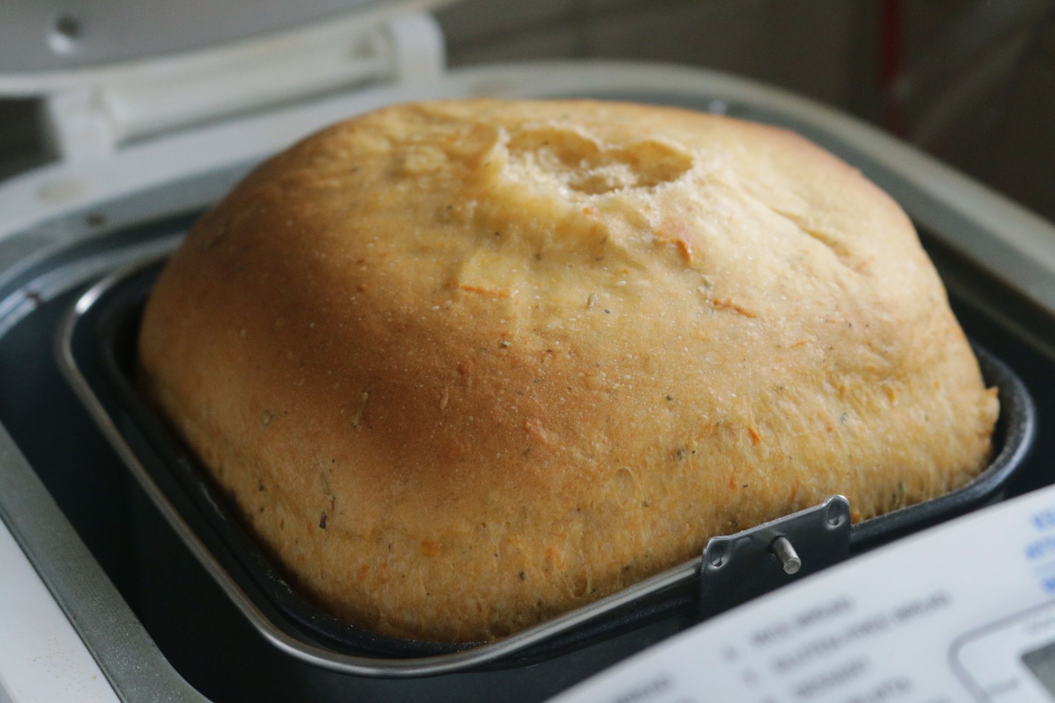 Stock photo showing elevated view of electric bread maker with freshly baked crusty bread.