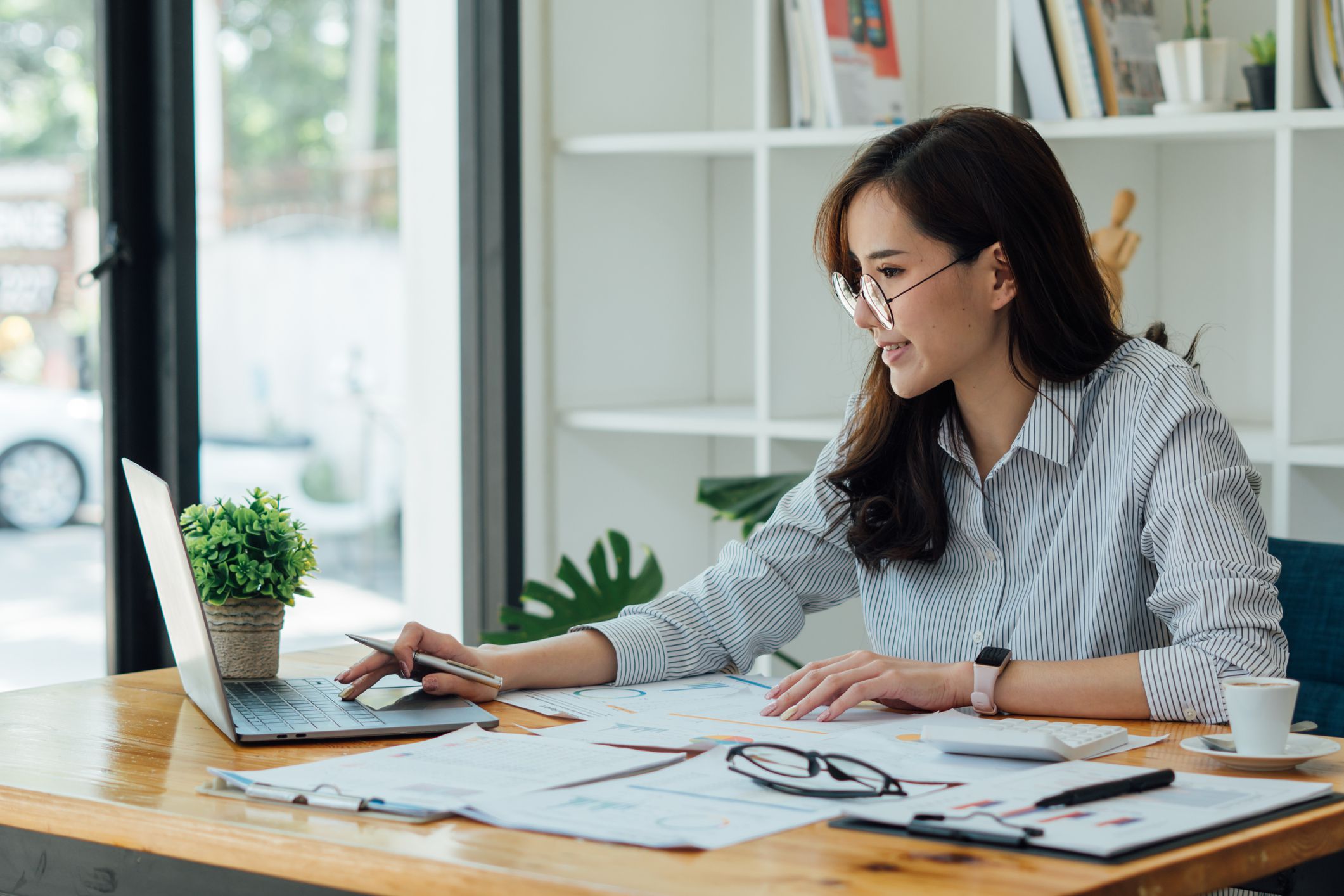 Asian female accountant or banker making calculations. Savings, finances and economy concept.