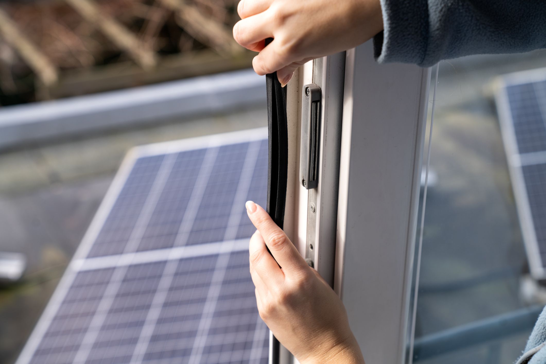 Young woman makes her home energy efficient with the help of draft strip and solar panels to save the planet.