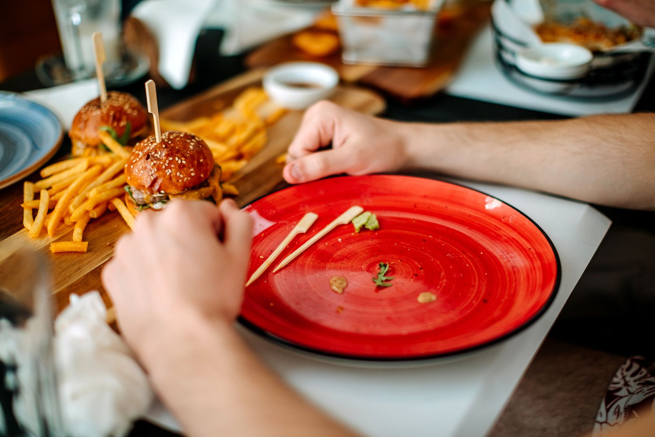 Friends having lunch together in restaurant eating burgers