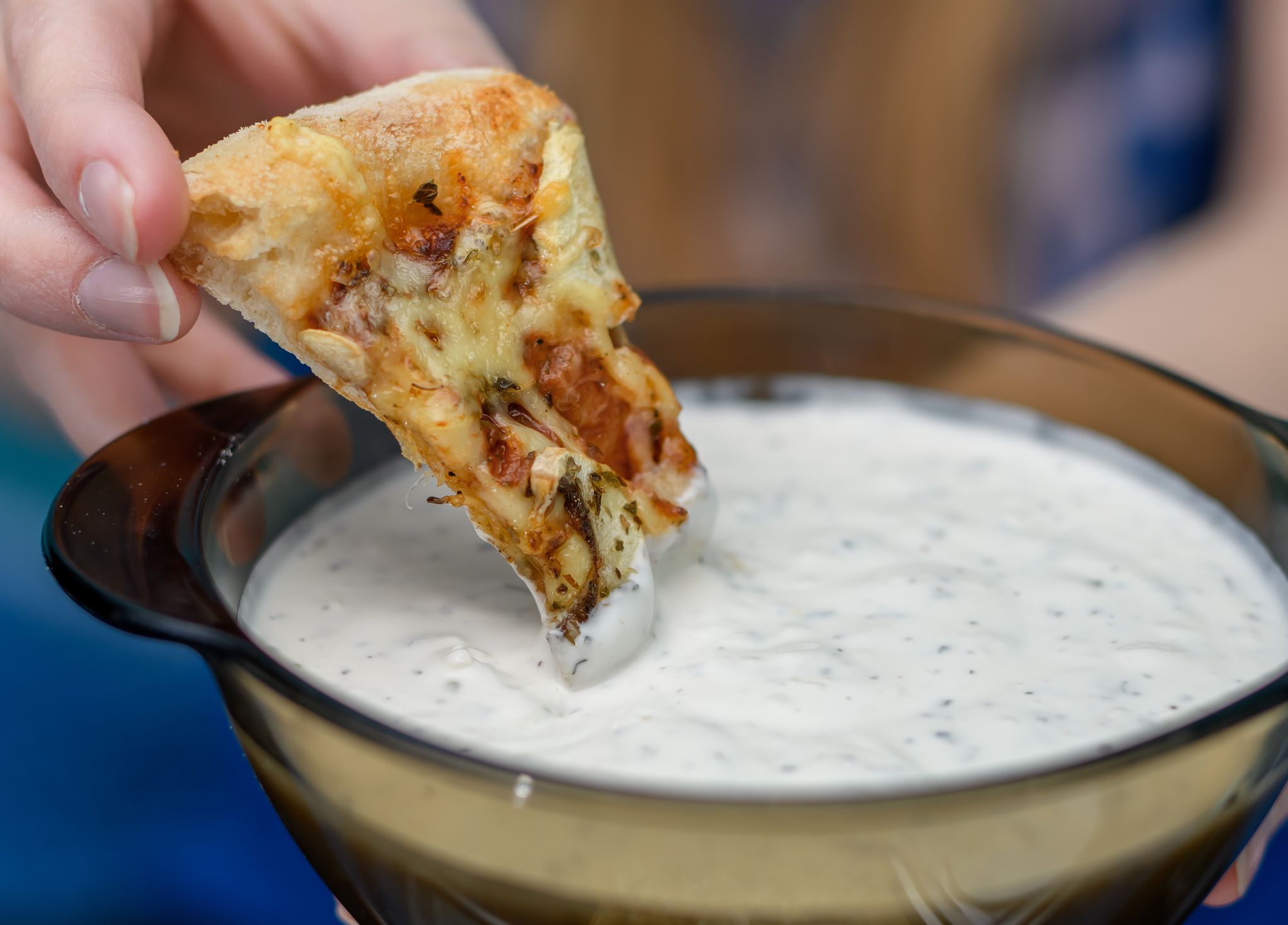 The girl eats pizza with garlic sauce