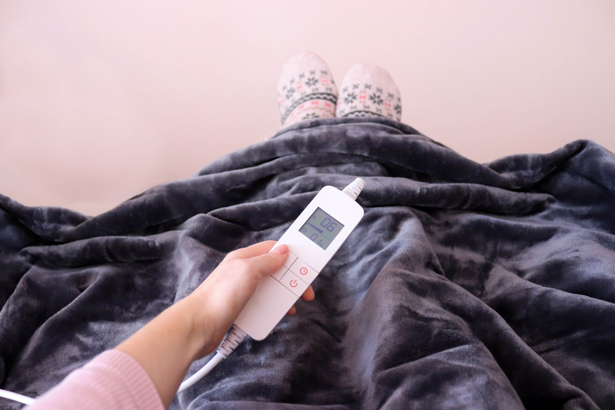 Electric blanket. Woman adjusting temperature on electric blanket.