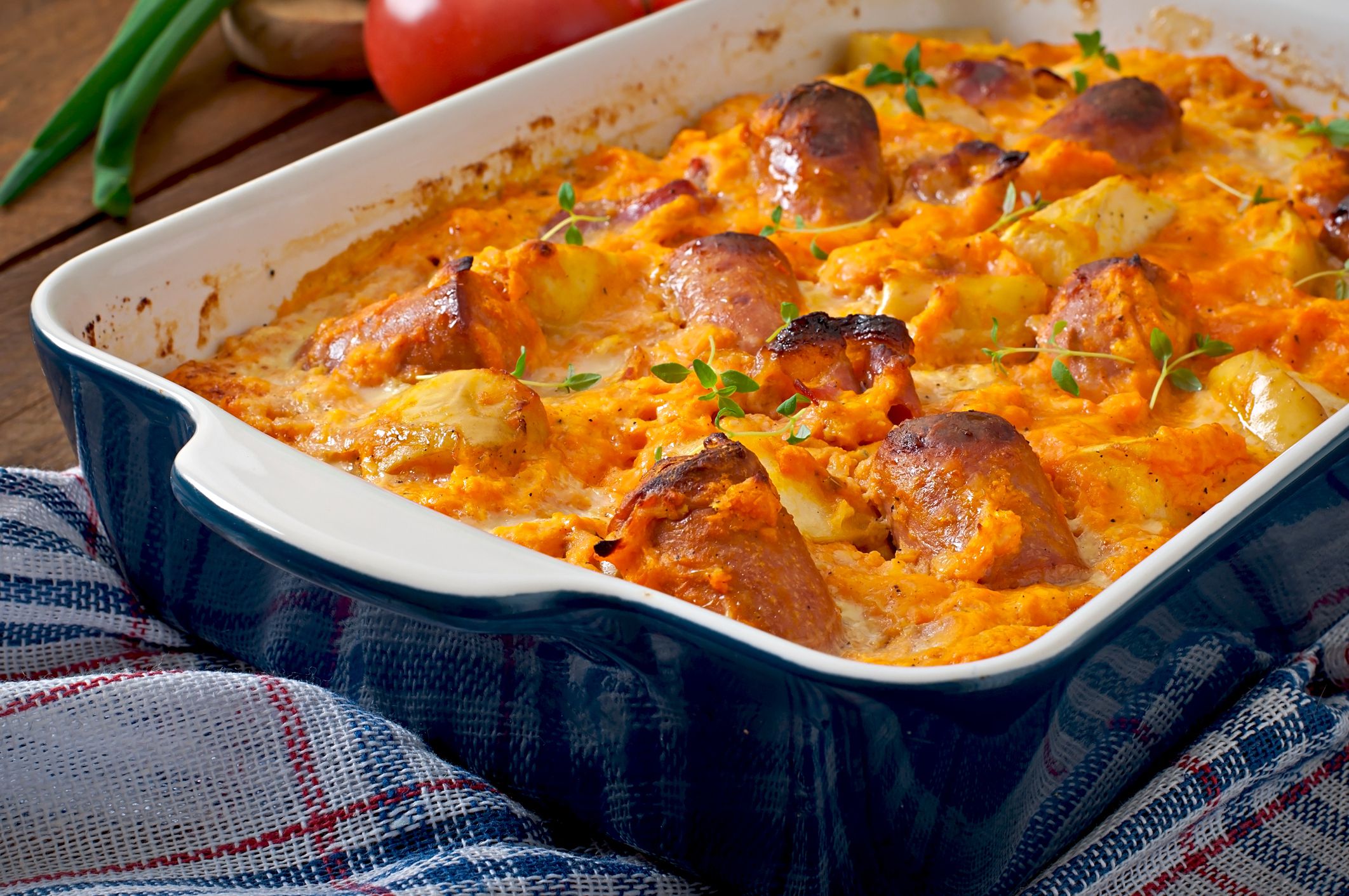 Casserole with sausage, bacon and apples in a pumpkin-cheese sauce