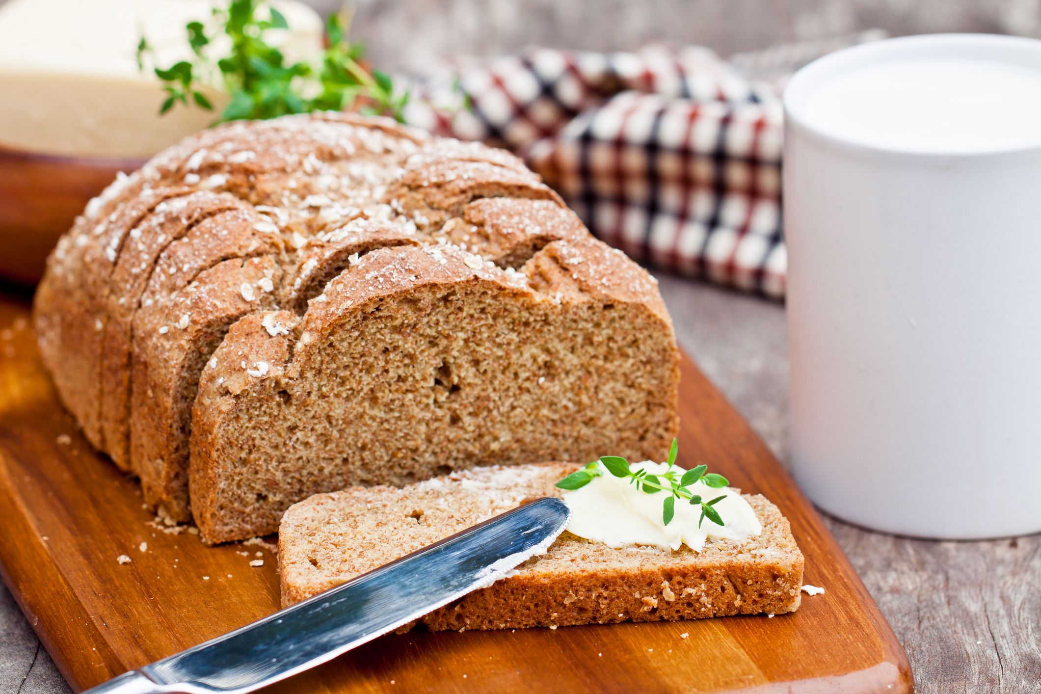 Sliced Irish stoneground soda bread with butter and thyme on the wooden table