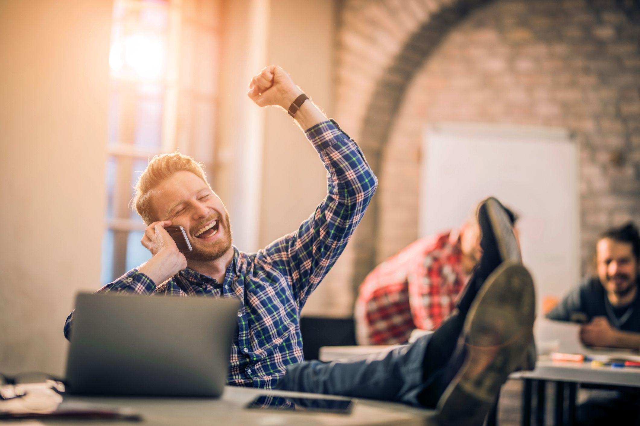 man on phone cheering in happiness