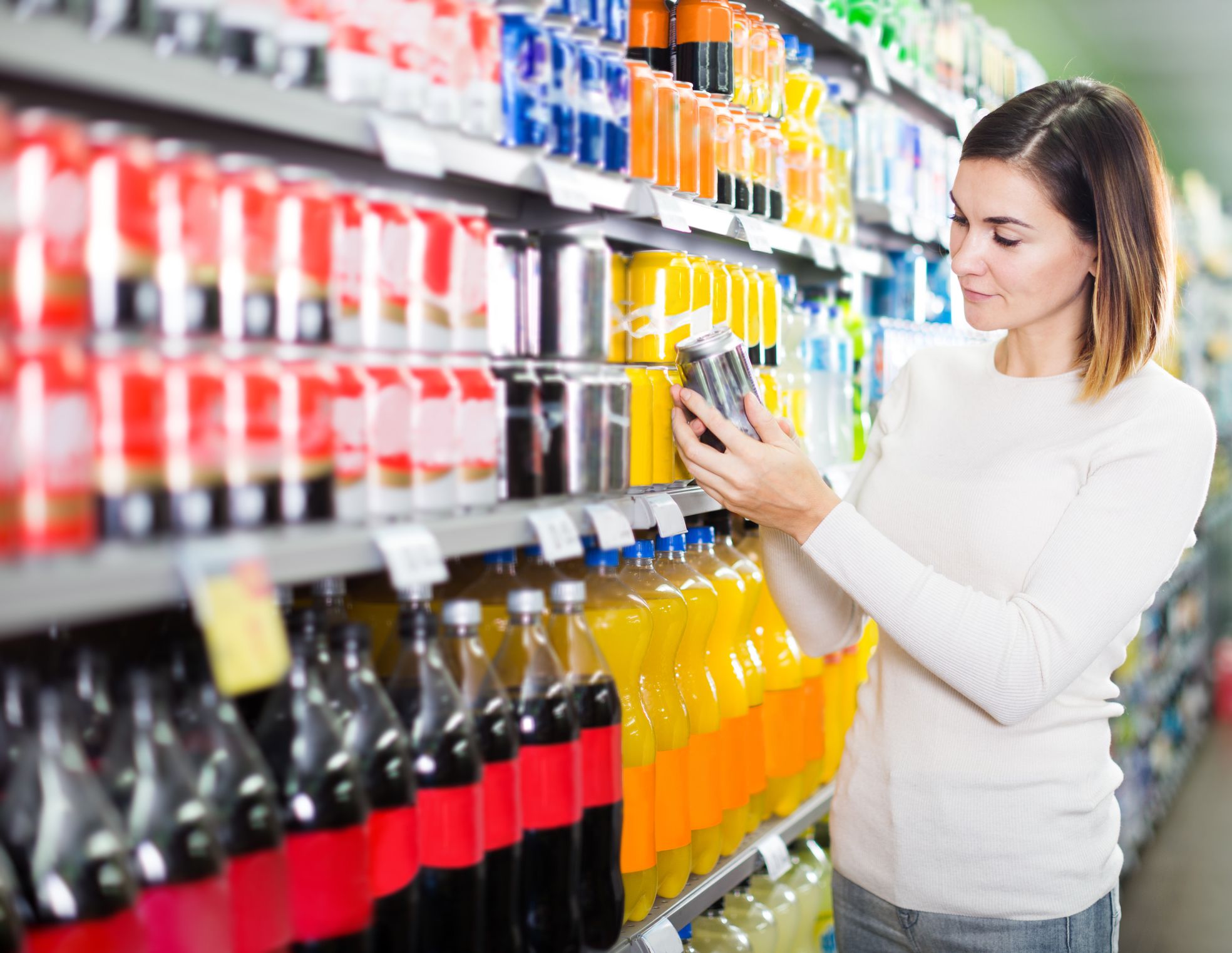 Girl customer looking for refreshing beverages in supermarket