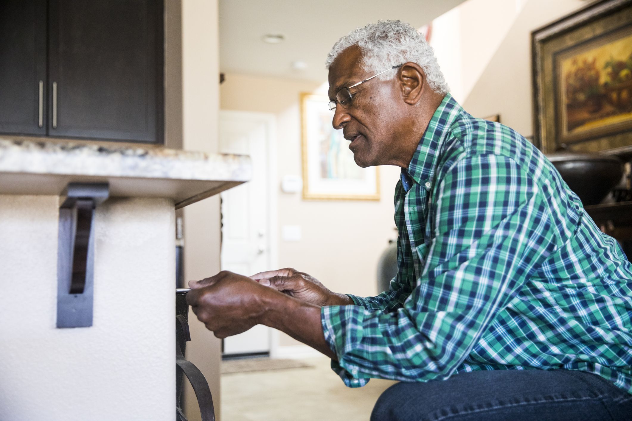 A senior Black man doing a simple home repair