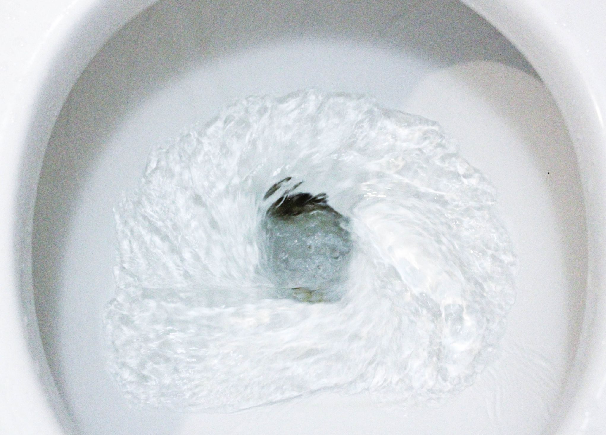 Toilet, Flushing Water, close up, water flushing in toilet, A photo of a white ceramic toilet bowl in the process of washing it off. Ceramic sanitary ware for correcting the need with an automatic flushing device