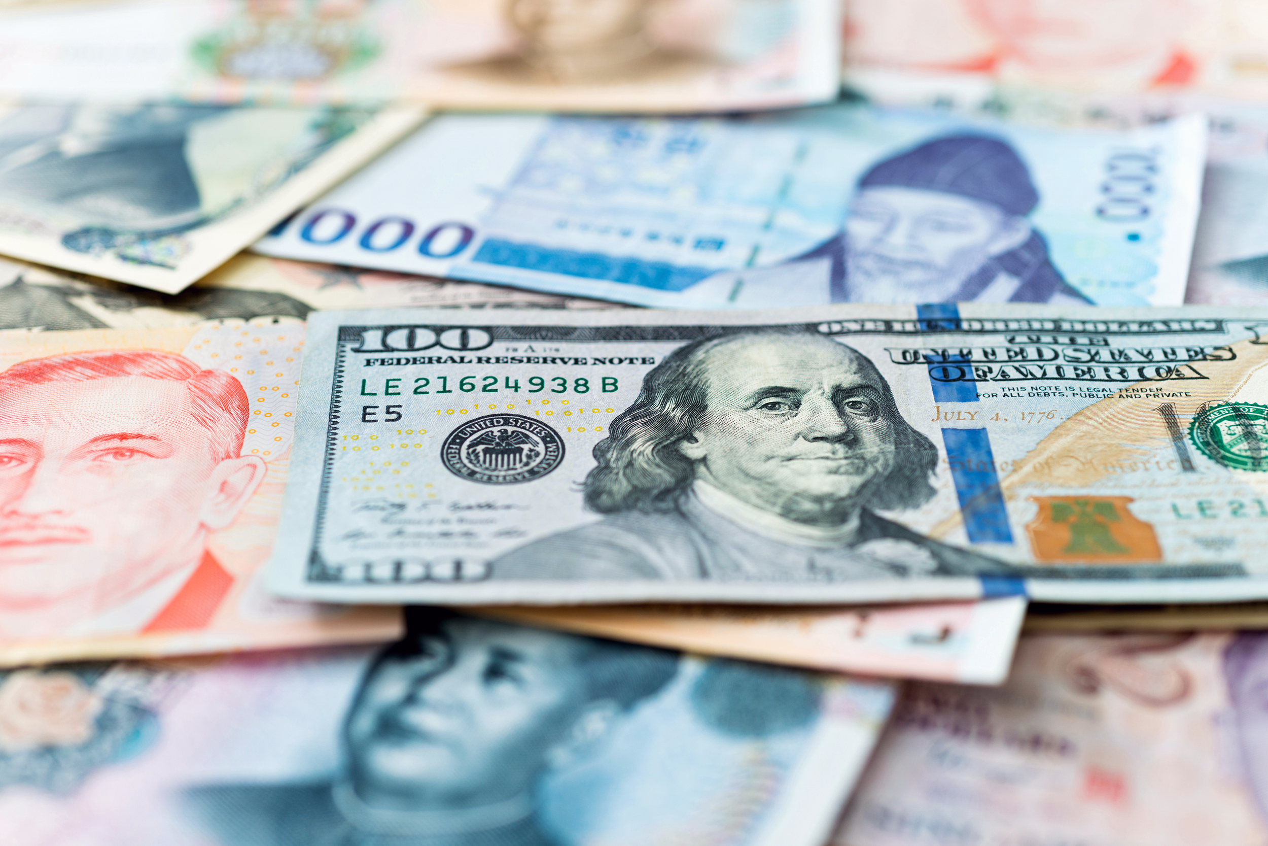 U.S. $100 bill and foreign money