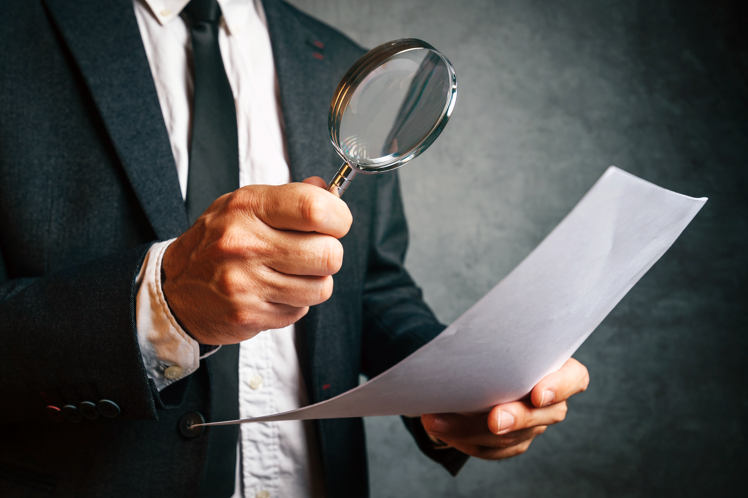 IRS employee investigating tax document with a magnifying glass