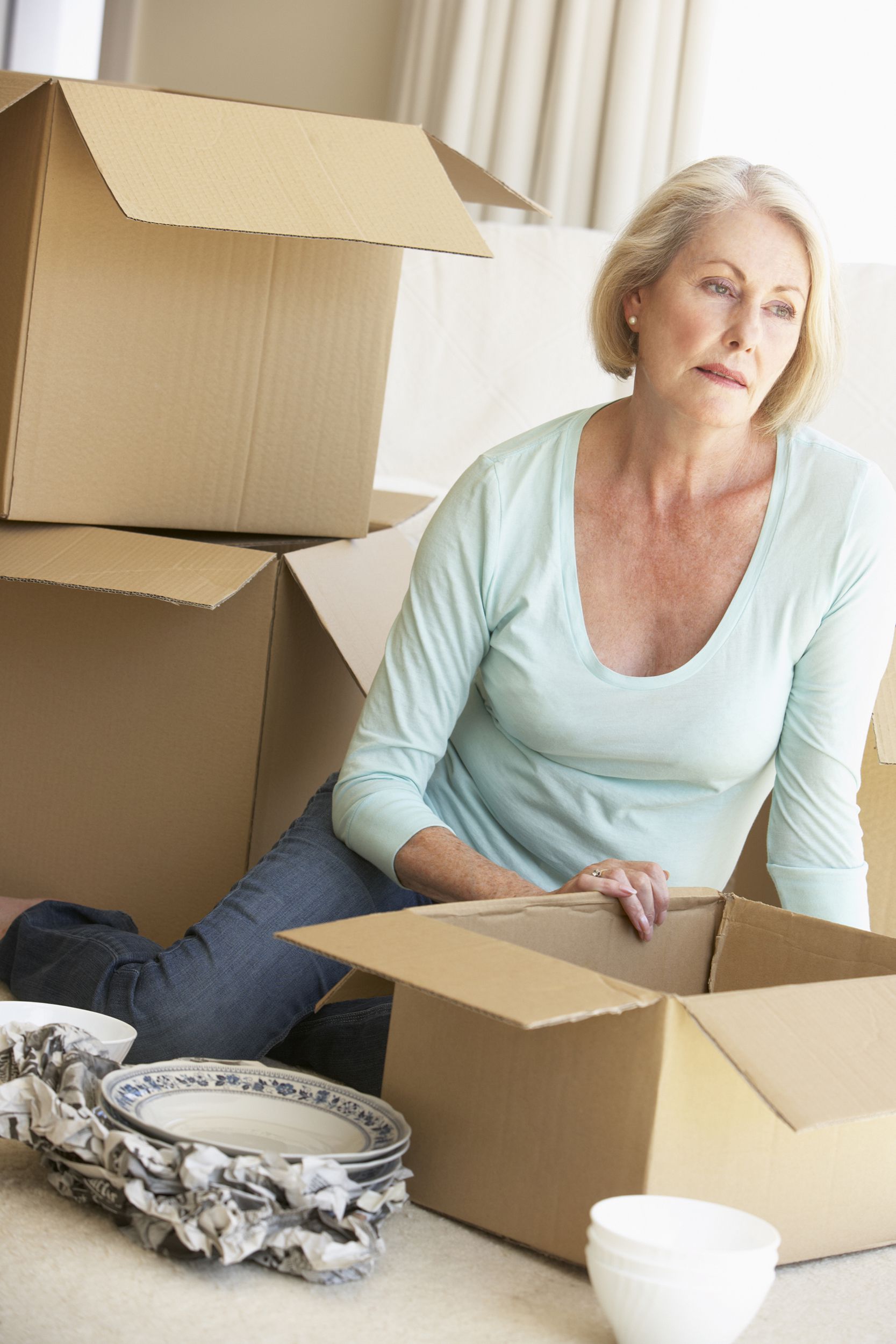 senior woman moving home and packing boxes