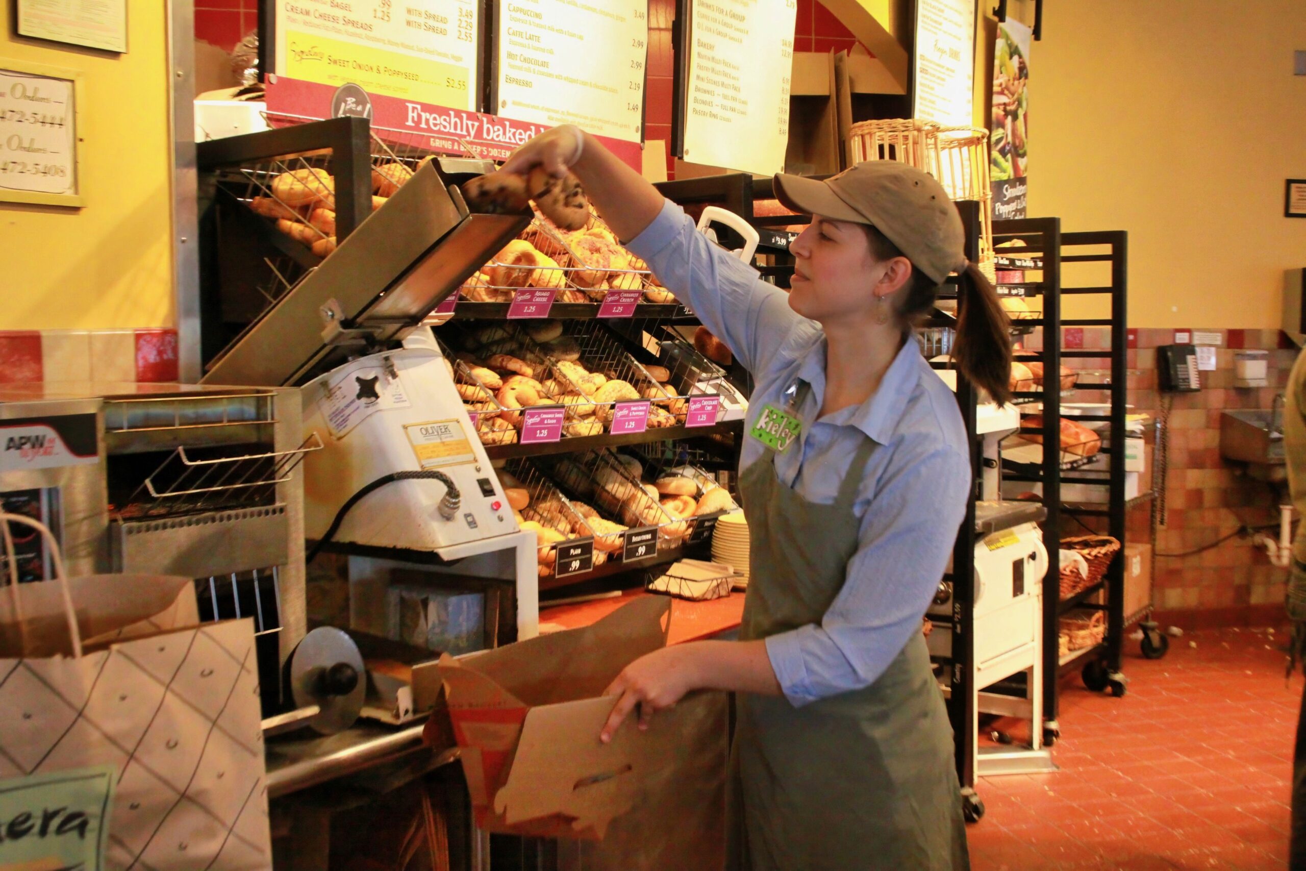 An employee places a bagel in a slicer machine at a Panera Bread restaurant in Cleveland, Tennessee