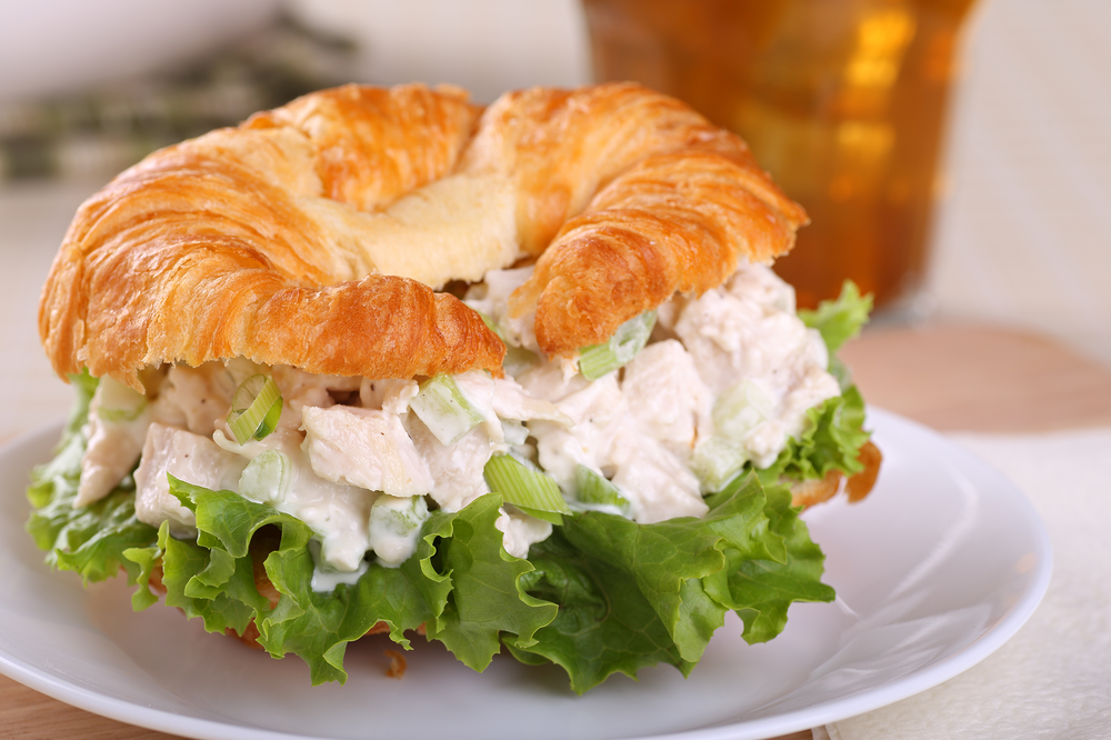 Chicken Salad Croissant Sandwich on a White Porcelain Plate, Selective Focus, on a White Tablecloth