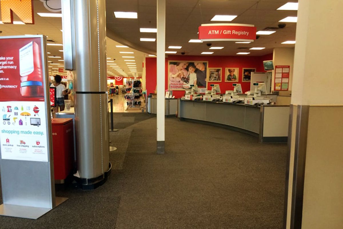 Customer service counter at a Target store, on the right, clothing aisles on the left, well-lit and clean