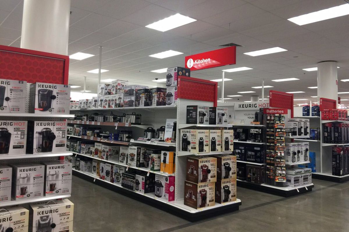 Four aisles in the kitchen section of a Target store, numerous coffee makers and other kitchen appliances organized neatly on the shelves, clean concrete floor and well-lit